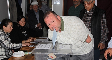 Kolları olmayan engelli seçmen, oy zarfını ağzıyla sandığa attı