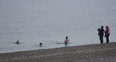 Turistler yağışa rağmen denize girdi